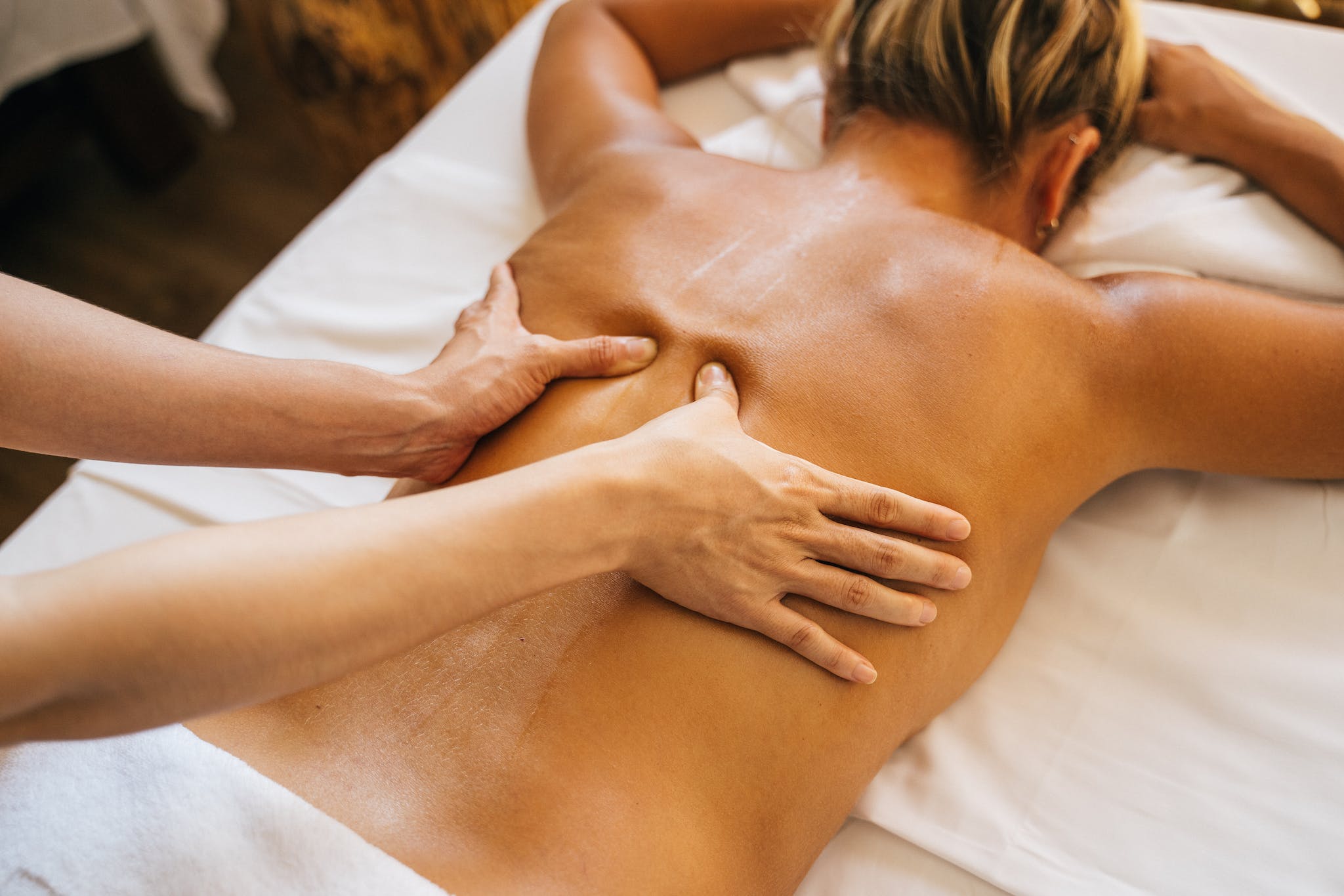 A Woman Lying Down while Having Her Head Massage by a Person